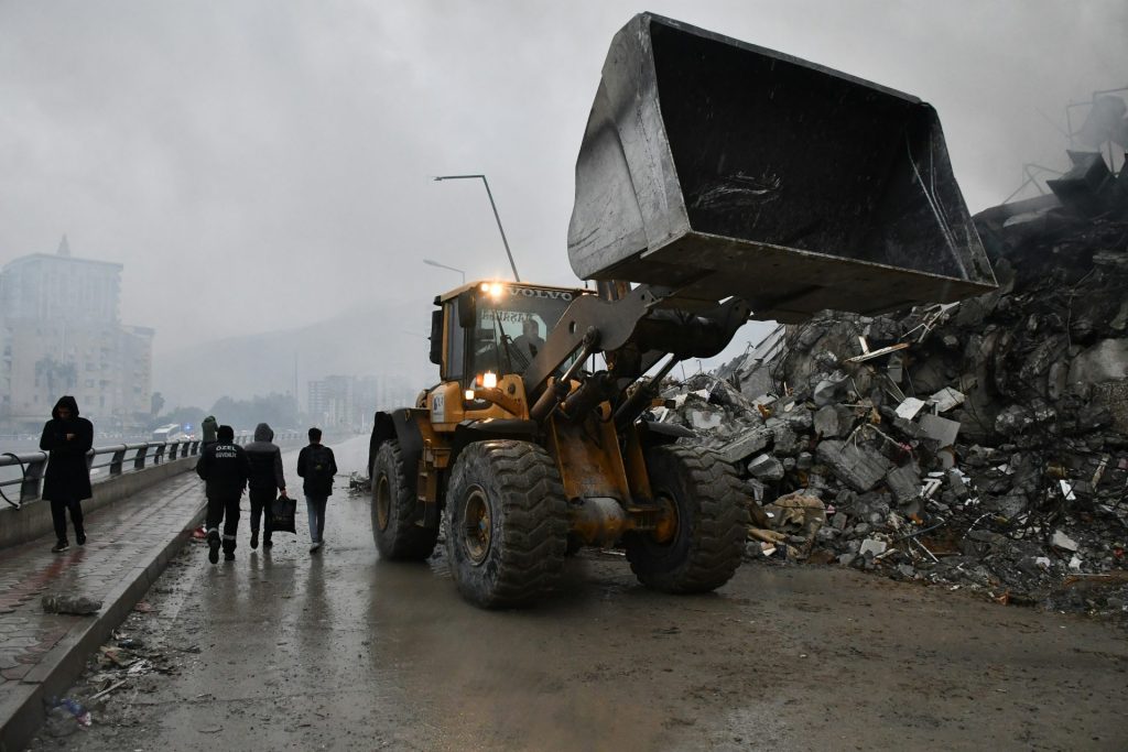 a bulldozer is parked in front of a pile of rubble